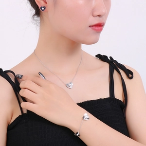 Detail view of silver heart pendant necklace with white shell pearl on a female model