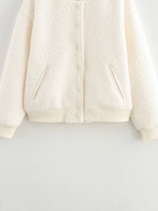 Detailed close-up of off-white sherpa fleece jacket with snap buttons and ribbed trim