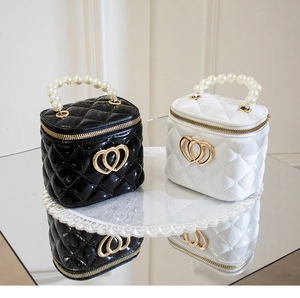 Close-up of mini quilted jelly bags with faux pearl handles and golden heart buckles