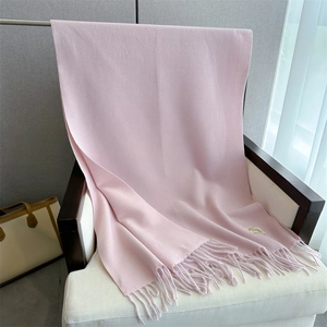 Close-up of soft light pink cashmere-like scarf with fringe detail on a chair