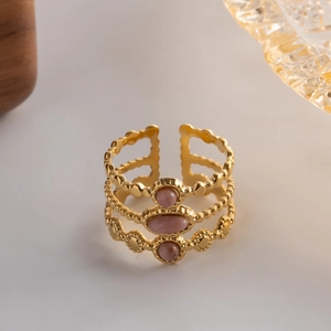 Macro detail of gold vintage triple-layered ring featuring three pink oval gemstones