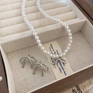 Collier ras du cou en perles élégantes avec pendentif nœud en argent et boucles d'oreilles