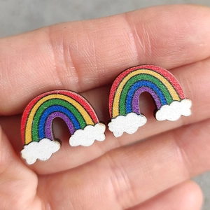 Boucles d'oreilles nuage arc-en-ciel scintillantes en bois tenues en main pour les détails