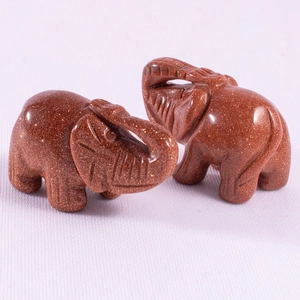 Macro shot of 1.5 inch elephant figurines carved from shimmering goldstone resin