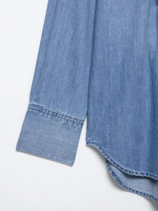 Detail of double-needle stitching and denim texture on light blue fashion shirt cuffs