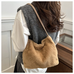 Detail view of the khaki faux fur shoulder bag with soft plush texture on model