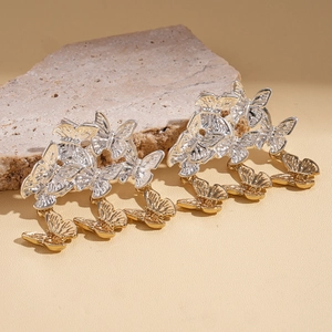 Boucles d'oreilles élégantes avec glands papillons argent et or sur fond de pierre naturelle