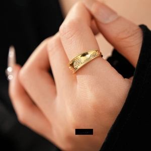 Anello aperto placcato oro con zirconi a cuore indossato sulla mano di una modella