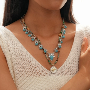 Detail of bohemian layered necklace with turquoise stone and sun moon pendant on a model