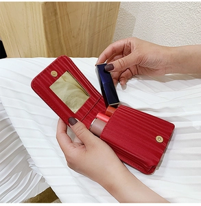 Detail view of red leather lipstick pouch with built-in mirror and magnetic closure