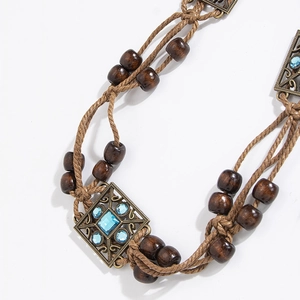 Detail of bohemian braided waist rope with brown wooden beads and blue gemstone pendant