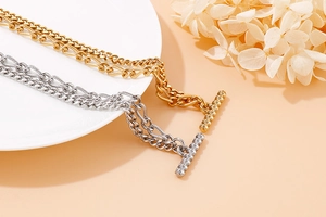 Détail de bracelets à double chaîne avec boucle OT en or et argent sur une assiette