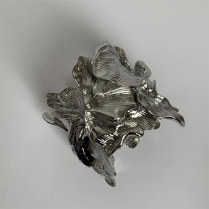 Macro shot of a silver floral metal cuff bracelet with artistic liquid metal petal texture