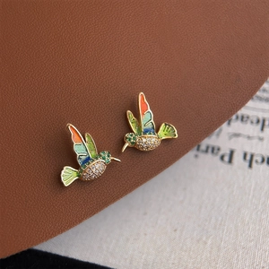 Macro shot of colorful enamel hummingbird studs with sparkling white zircon details