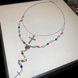 Close-up of double-layer necklace with multi-color stones and silver cross pendants