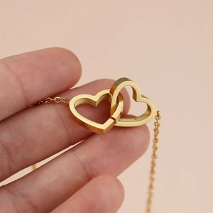 Minimalist double heart interlocking pendant necklace in polished gold stainless steel finish