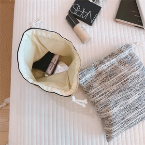 Macro view of black and white tweed drawstring pouches with soft cream cotton lining