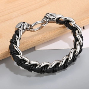 Detail of woven leather bracelet featuring silver punk skull clasp and spiral texture