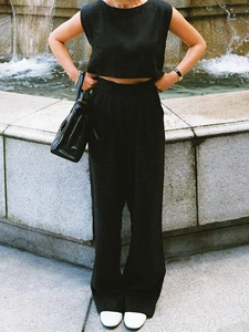 Detail von schwarzem ärmellosem Crop-Top und weiter Leinenhose für den Sommerlook