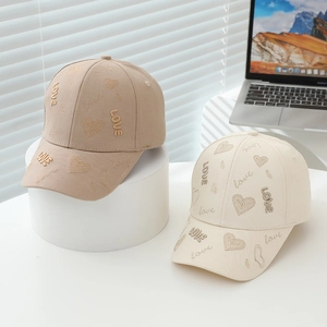 Détail de la broderie LOVE et des motifs de cœur sur les casquettes enfant beige et kaki