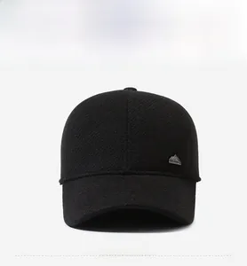 Close-up of black winter baseball cap featuring mountain metal badge and thermal lining