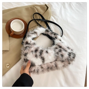 Detail of spotted plush crescent bag with soft fur texture and black shoulder strap