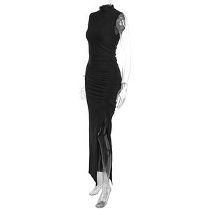 Detail of black ruched bodycon dress showing high slit and side pleated textures
