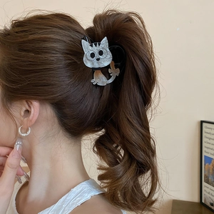 Vue détaillée d'une pince à cheveux chat mignon blanc nacré sur une queue de cheval