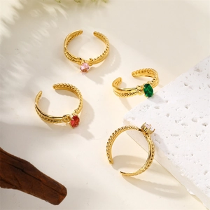 Set de quatre bagues ajustables en acier doré avec des pierres précieuses ovales colorées
