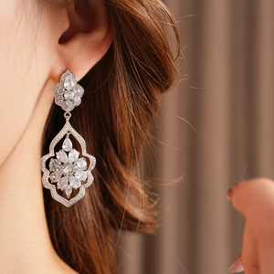 Vue détaillée de boucles d'oreilles fleur en argent avec zircon et pampilles ciselées