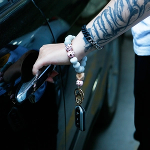 Detailed view of a silicone bead wristlet keychain with wooden butterfly bead and metal clasp