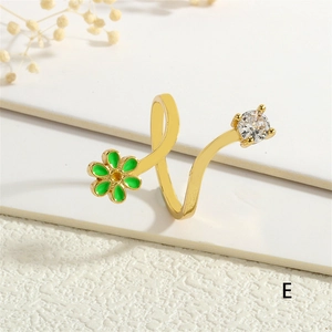 Detail of gold flower ring with green enamel petals and sparkling cubic zirconia stone
