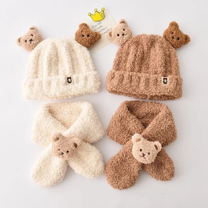 Detail of plush bear ears on baby hats and scarves in beige and brown colors