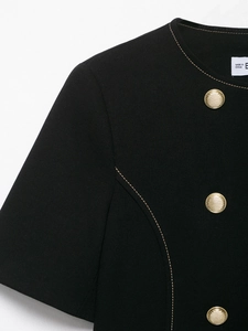 Detail of black tweed blazer with gold textured buttons and contrast stitching details