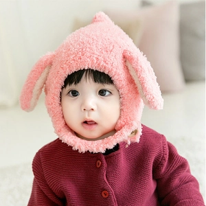 Close-up of pink plush baby winter hat featuring cute rabbit ears on a lovely infant
