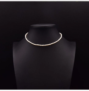 Macro view of creamy white natural pearl choker necklace on a black jewelry bust