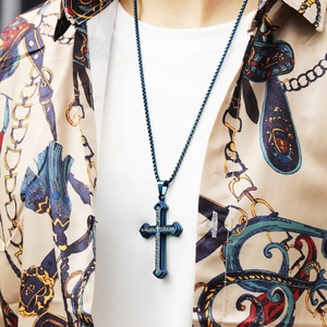 Close-up of a blue punk style stainless steel cross necklace worn by a male model