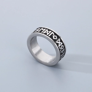 Macro shot of silver Nordic Viking runes engraved on a brushed stainless steel ring