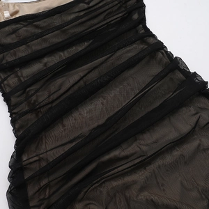 Detail of black mesh dress featuring elegant ruched texture and nude inner lining