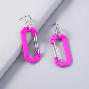 Macro shot of pink carabiner tassel earrings with sparkling rhinestones and silver hooks