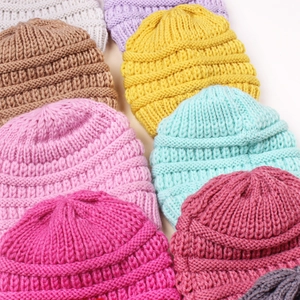 Close-up of chunky rib-knit texture on colorful candy-colored winter beanies
