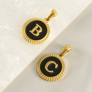 Detail of 18K gold lace pendants with black enamel B and C letter charms on silk