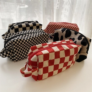 Detailed display of assorted velvet makeup bags with checkerboard and cow patterns