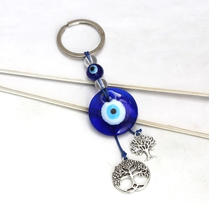 Turkish Evil Eye keychain with Tree of Life charms and blue glass beads on white background