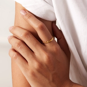 Close-up of a twisted gold rope ring for women worn on a finger for stacking style