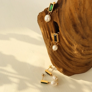Vintage gold drop earrings with green zircon and natural freshwater pearls on wood