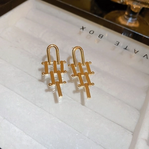 Detailed view of golden irregular geometric earrings with a modern tiered linear design