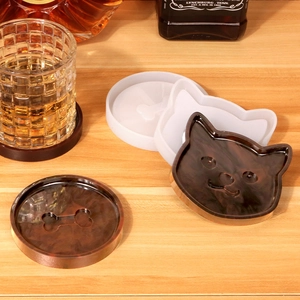 Detailed cat and bone silicone mold with translucent resin coasters on wooden tabletop