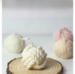 Detailed close-up of wool ball scented candle with realistic woven texture on wood slice