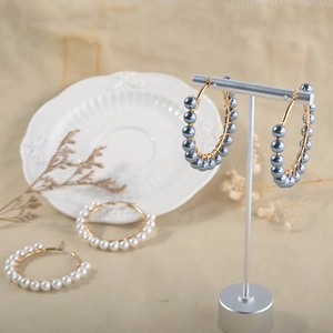 Detail of beaded pearl hoop earrings with wire wrapping technique in blue and white